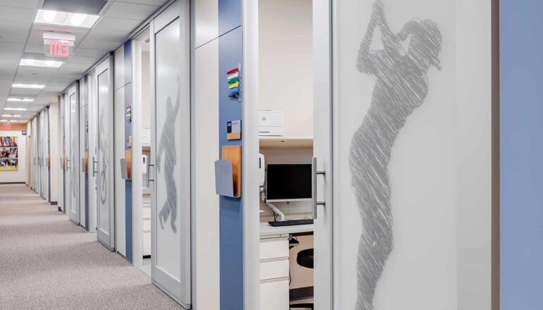 The orthopedic exam corridor with sports graphic film coverings on sliding exam room doors.