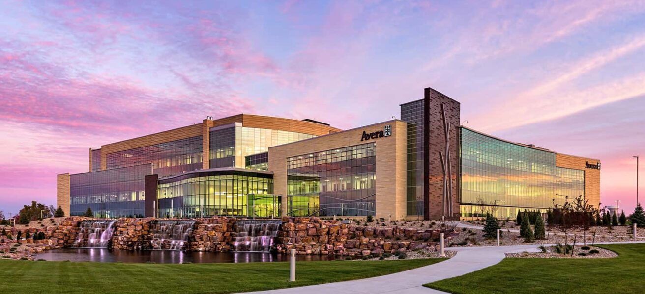 Exterior view of the entire building at dusk, featuring curtainwall details and waterfall landscapes.