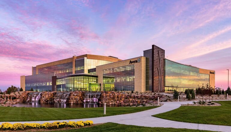 Exterior view of the entire building at dusk, featuring curtainwall details and waterfall landscapes.