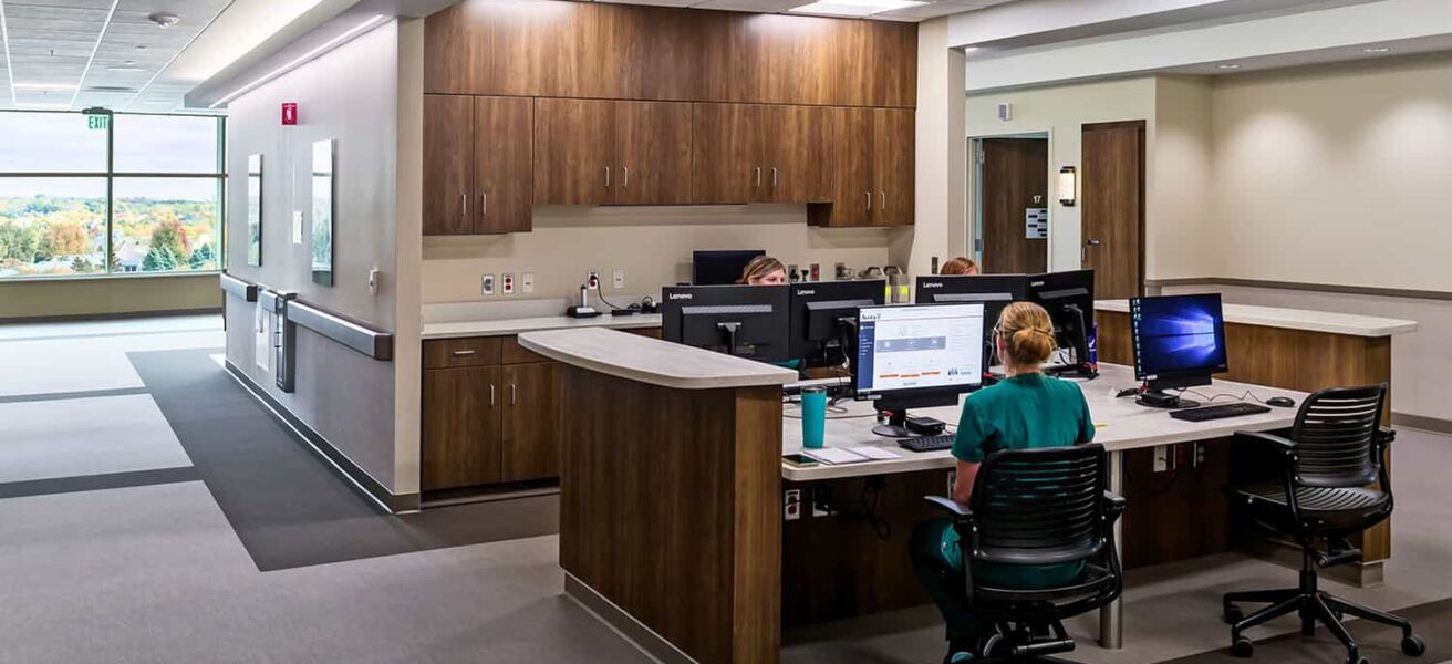 Open nurse station with wood casework and access to daylight and views.