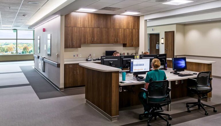 Open nurse station with wood casework and access to daylight and views.