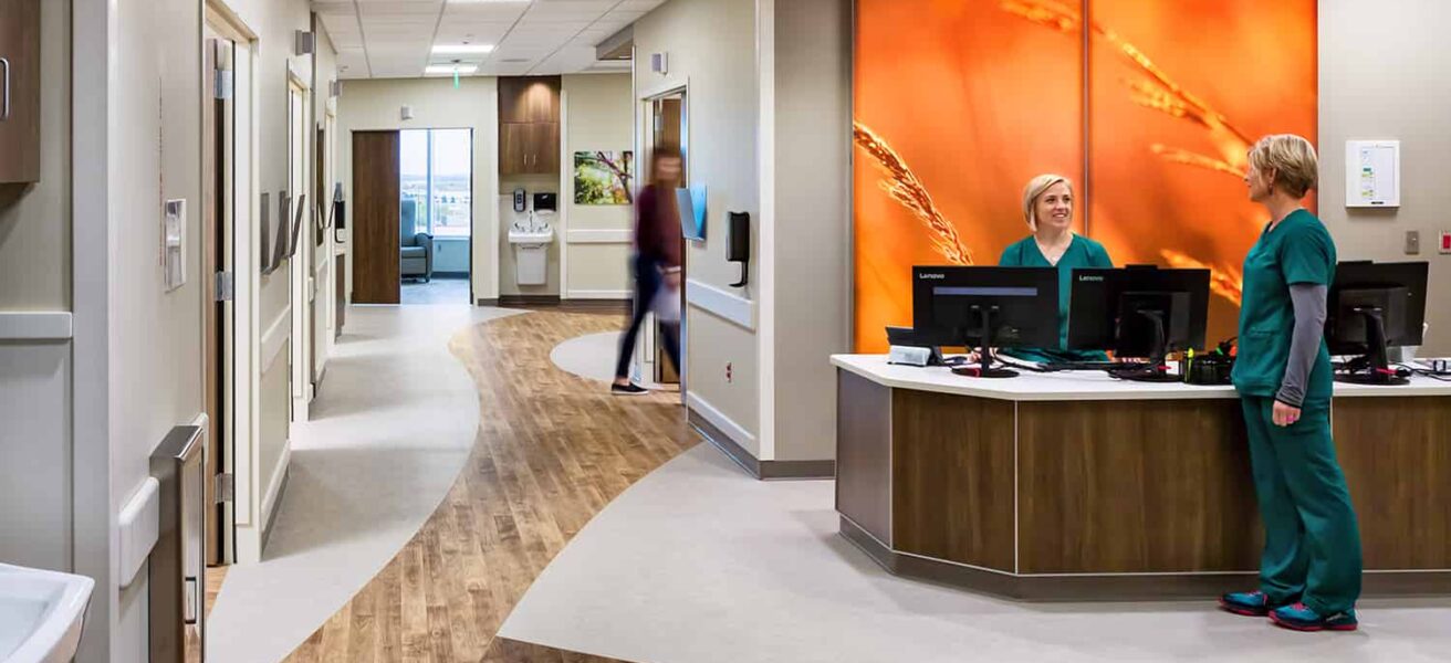 Nurse station and corridor in the pre/post-orthopedic suite, featuring wood accents and floor to ceiling wall graphics.