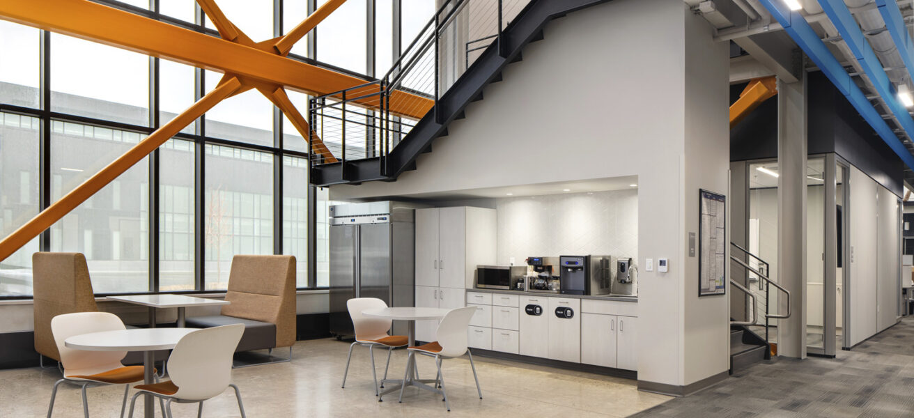 An Aldevron employee coffee bar touchdown with abundant natural light and drop-in work booths.