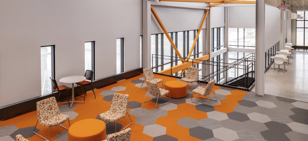 An open collaboration space with orange hexagonal carpet patterns.