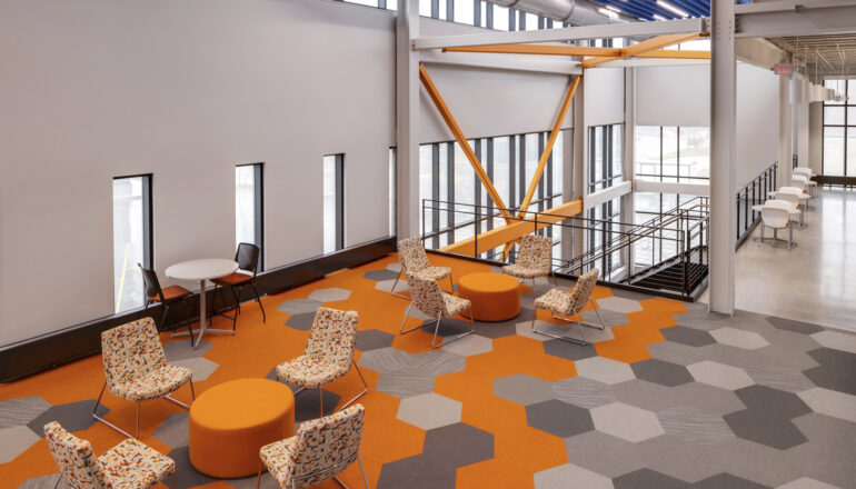 An open collaboration space with orange hexagonal carpet patterns.