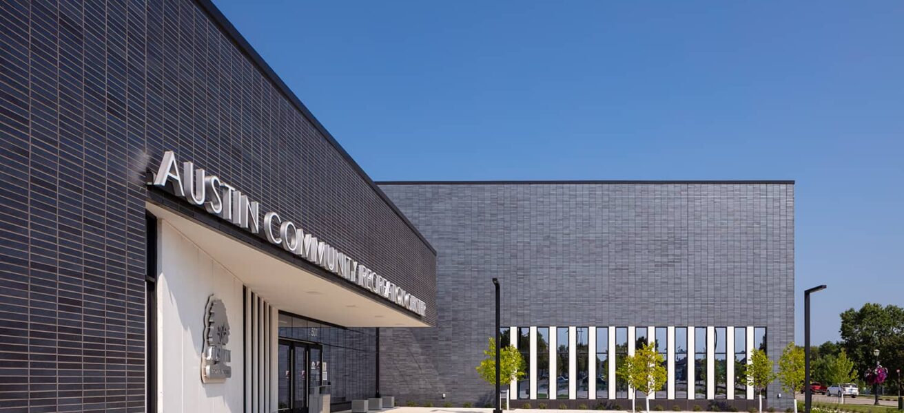 Exterior entry with courtyard and local city emblem on the wall.