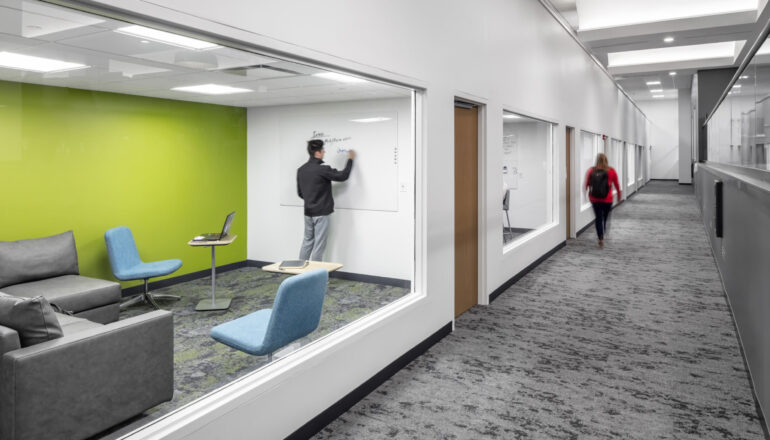 Glass-enclosed study room with a bright green accent wall.