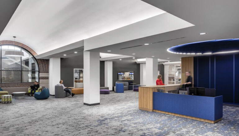 A library welcome desk with blue wayfinding elements.