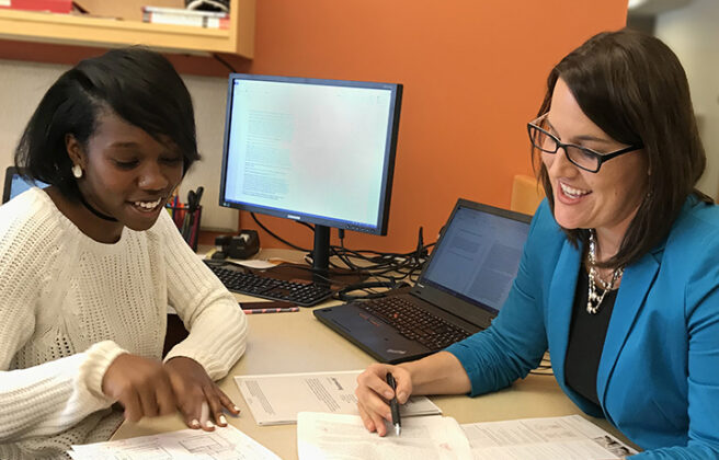 Stefnee Trzpuc and a design research student intern discuss a collaborative research paper.