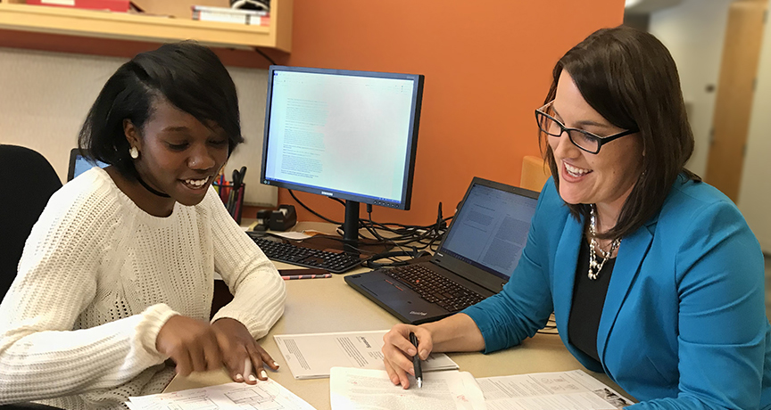 Stefnee Trzpuc and a design research student intern discuss a collaborative research paper.