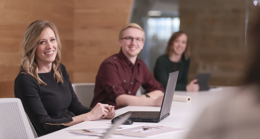 Project Manager Anna Pratt smiles as she holds a meeting with other Omaha employees and project team members