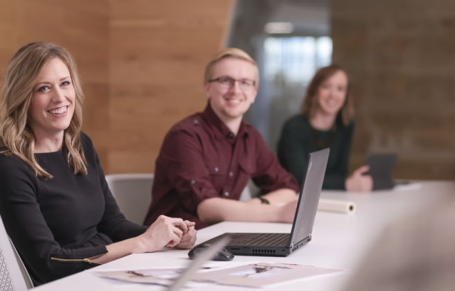 Project Manager Anna Pratt smiles as she holds a meeting with other Omaha employees and project team members