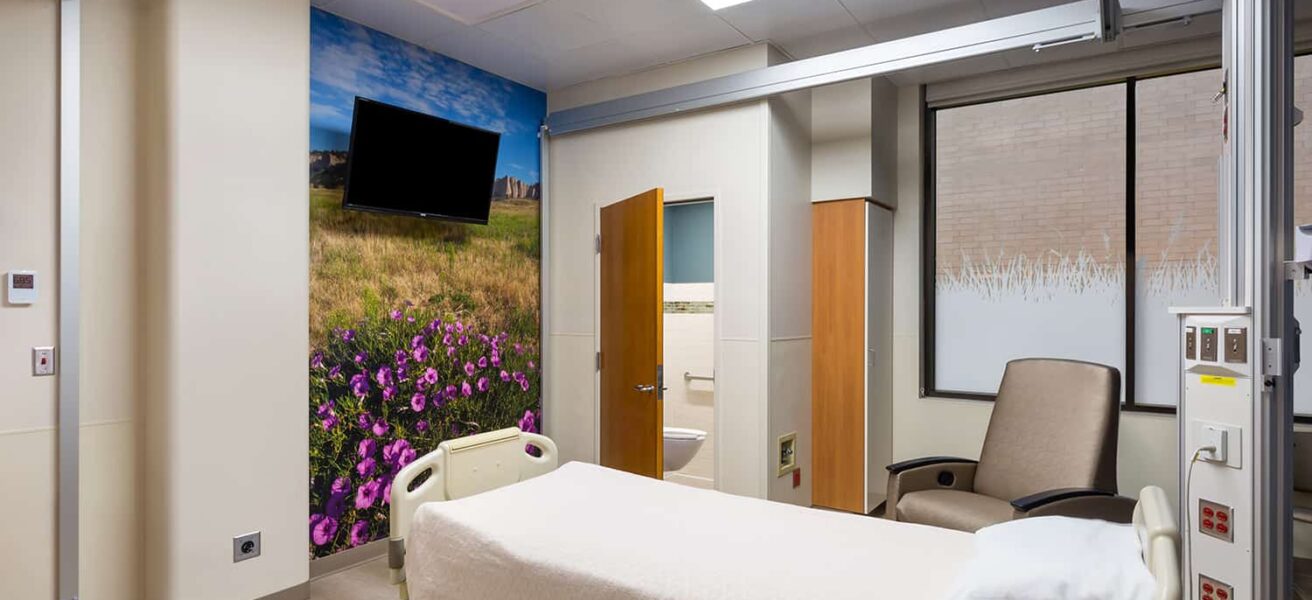 A burn unit room with wildflower wall mural and private bathroom.
