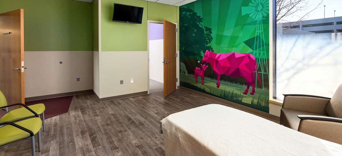 A patient room with a wall mural of cows.