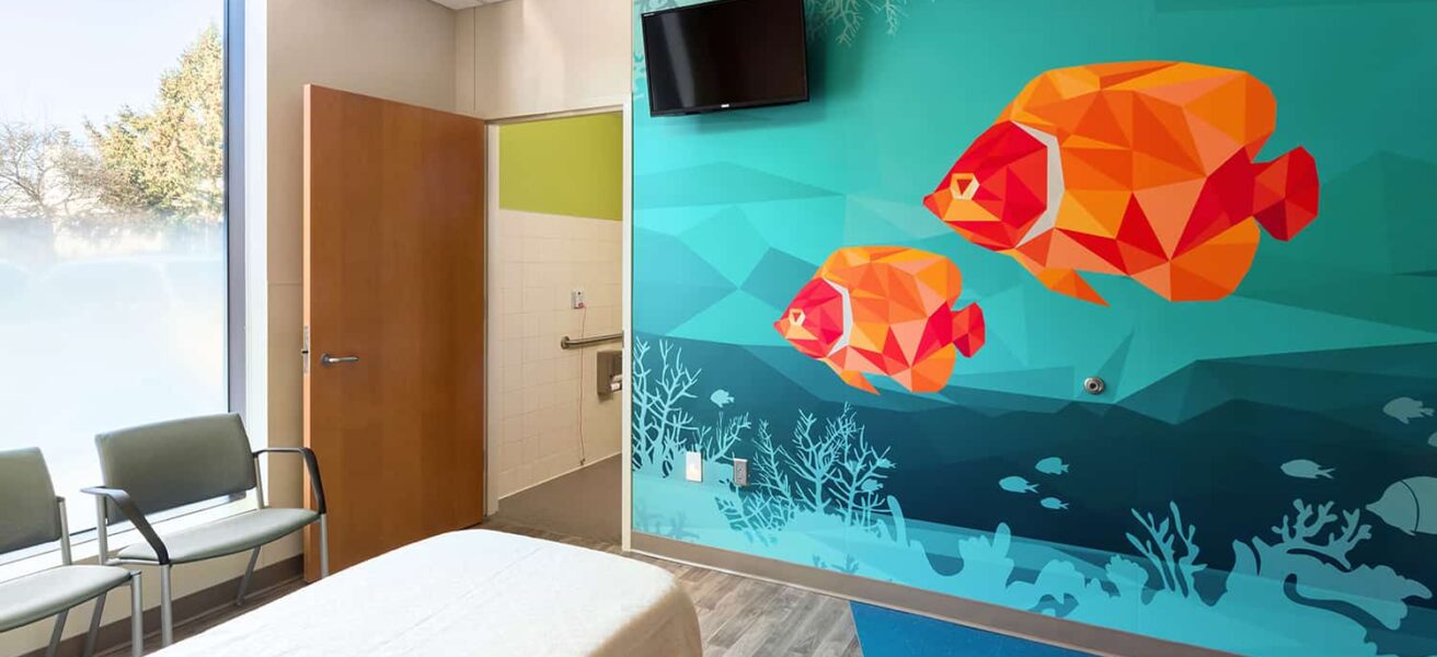 The footwall of a patient room with a wall mural of tropical fish.