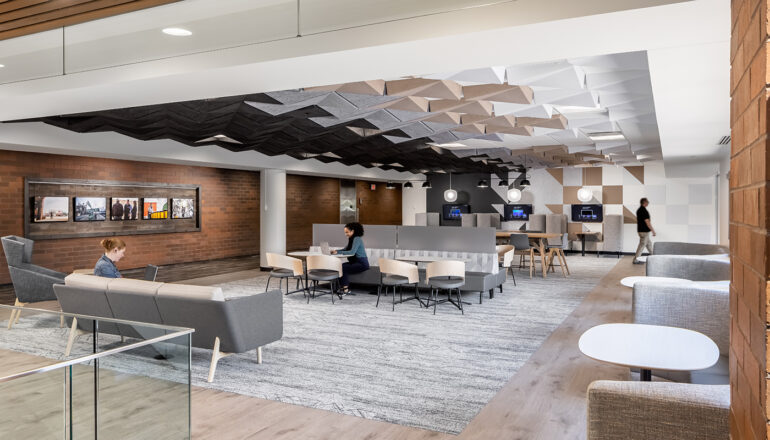 Overall view of a CHS work cafe with technology, acoustical ceiling tiles, and a variety of seating.