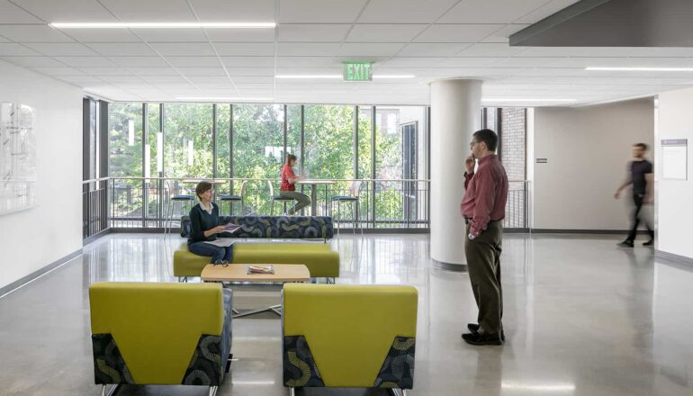 An open third floor lounge with brightly colored furniture and whiteboard workspace.