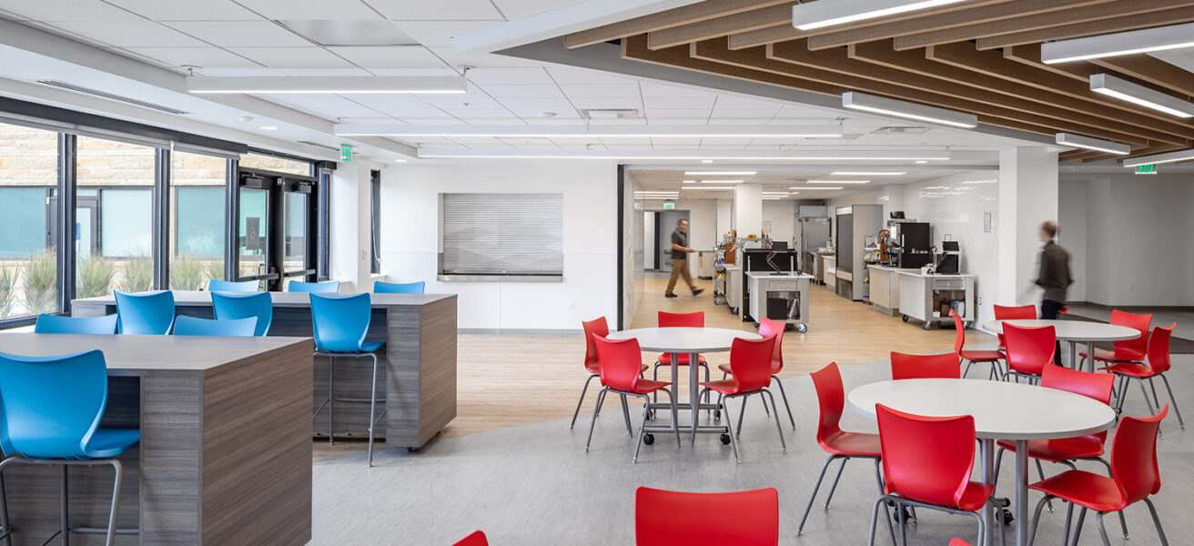 Bright blue and red chairs provide seating options outside of the Cotter Schools cafeteria