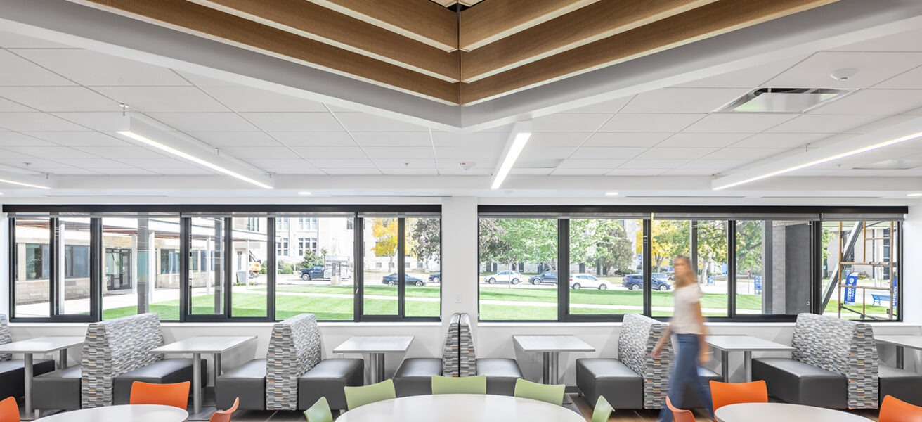 A person walks past brightly colored chairs and seating options outside the Cotter Schools cafeteria