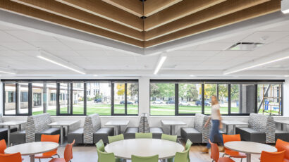 A person walks past brightly colored chairs and seating options outside the Cotter Schools cafeteria