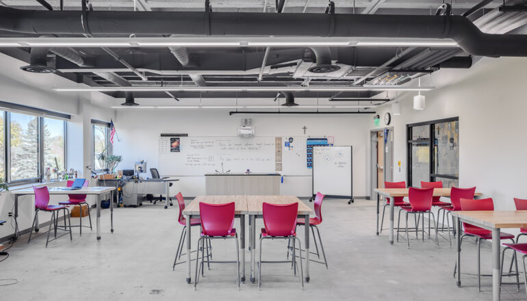 Movable red chairs and tables give space and teaching options in a classroom for 21st Century learning at Cotter Schools