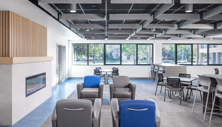 A blue themed study lounge features armchairs, study tables, and a small fireplace for Cotter Schools students