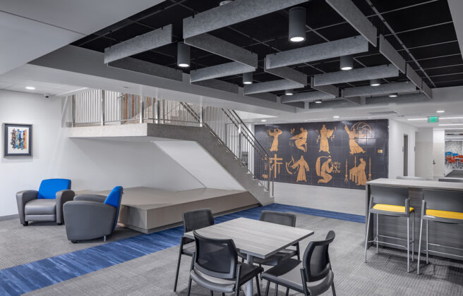 Blue themed study chairs lead to Greek inspired wall art and a small staircase in Cotter Schools