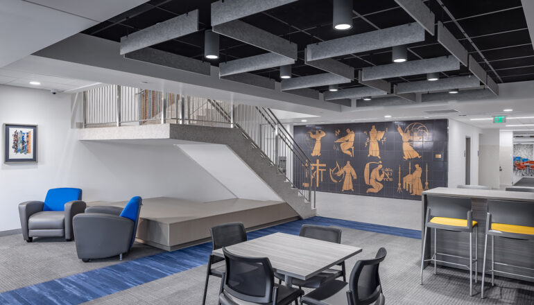 Blue themed study chairs lead to Greek inspired wall art and a small staircase in Cotter Schools