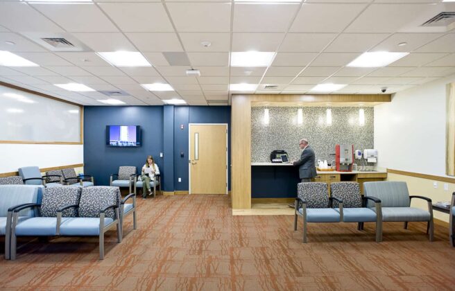 A patient waiting area has a coffee station and options for seating to accommodate various size groups of visitors
