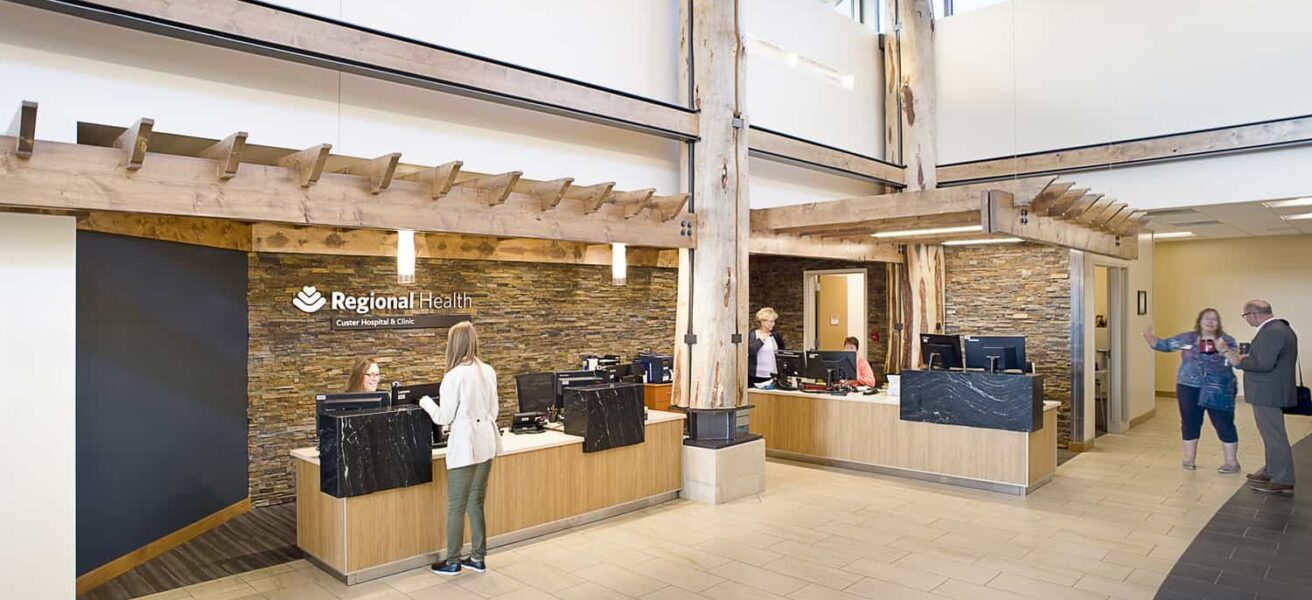 People check in in the expansive, white pine lobby of the Custer Hospital