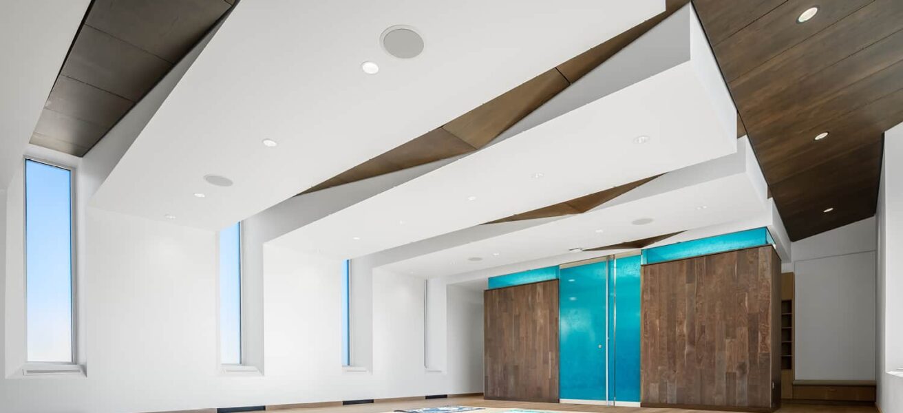 Full view of the multifaith center with worship mats on the floor and illuminated blue privacy glass at the entry.