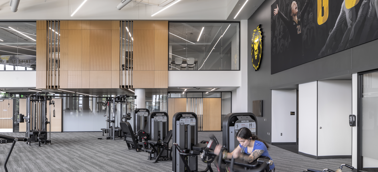 A person with a wheel chair works out in the welcoming Lund Center's cardio area