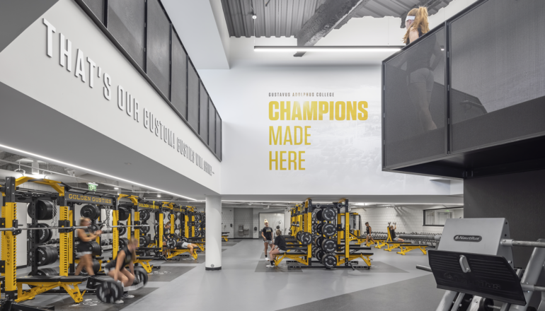 Students work out in the GAC Lund Center weight room, complete with high ceilings and yellow equipment