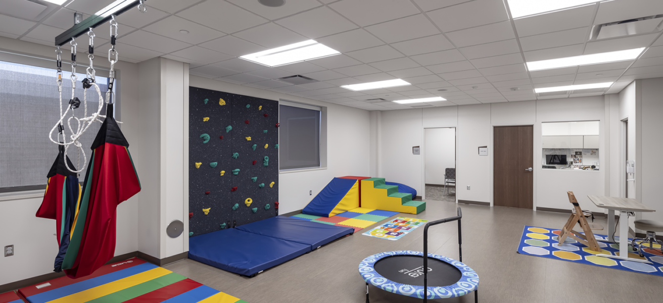 The pediatric physical therapy gym with rainbow colored exercise equipment.