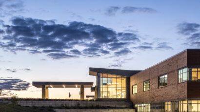 A person walks into the front entry of the JCRHC at dusk, as seen from a distance.