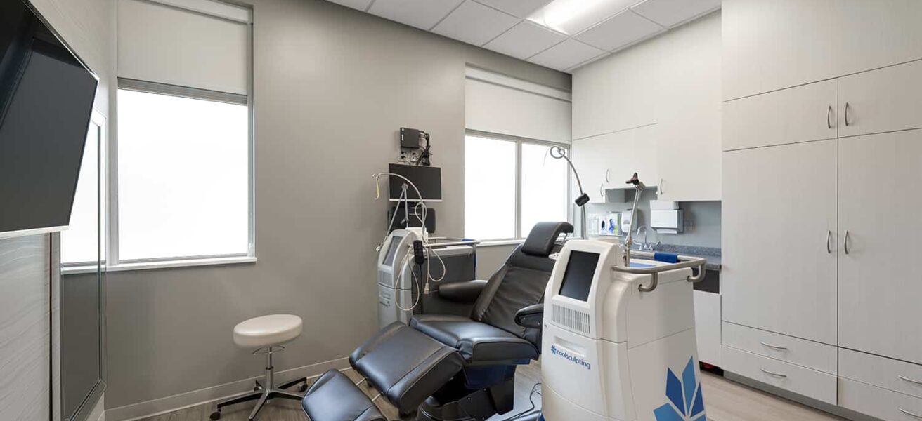 A dermatology procedure room with large monitor and special equipment.