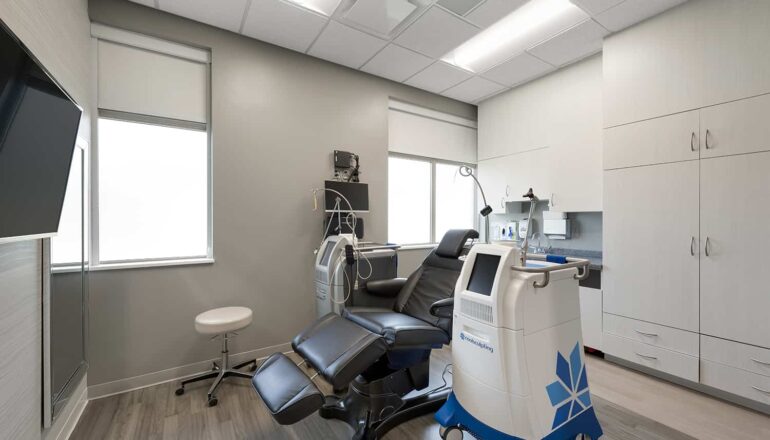 A dermatology procedure room with large monitor and special equipment.