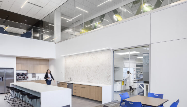 A person walks toward a window looking into the quality control lab.