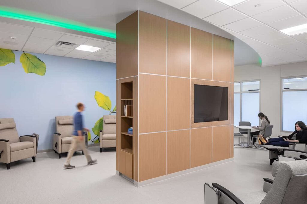 Group therapy space with technology and reading resources and comfortable furniture.