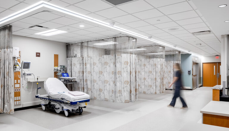 A nurse walks through the MMC Ashland Surgery Center PACU. Patients beds are divided by privacy curtains and are close to staff spaces