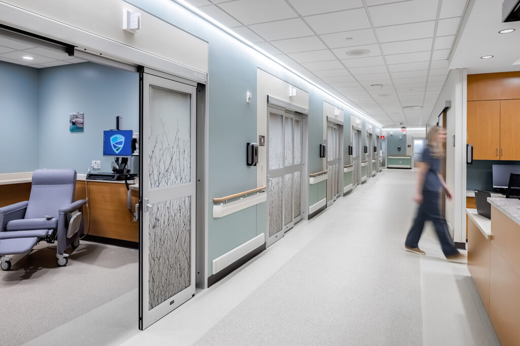 A nurse walks between the pre-post rooms and the nurses station in the MMC Ashland Surgery Center
