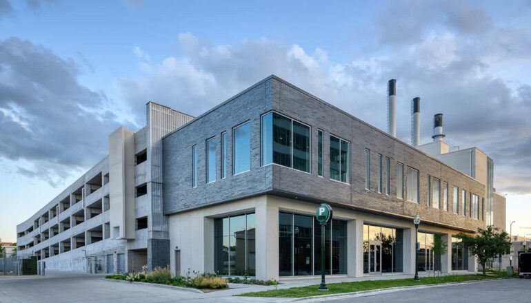 Exterior dusk view of parking ramp and storefronts.