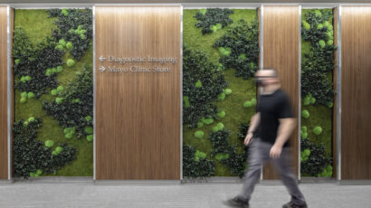 A person walks past a Mayo Clinic Health System green wall.