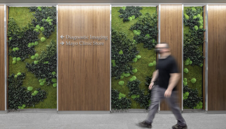 A person walks past a Mayo Clinic Health System green wall.