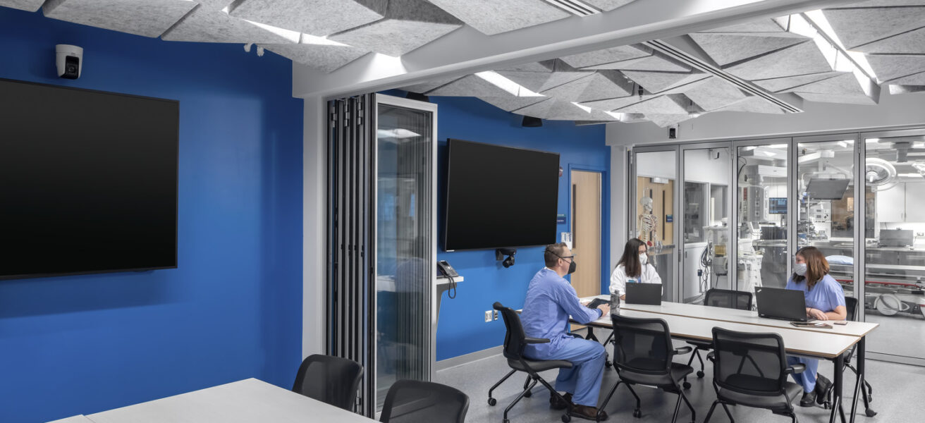 People hold a debrief meeting after training in the Mayo Clinic simulation center.