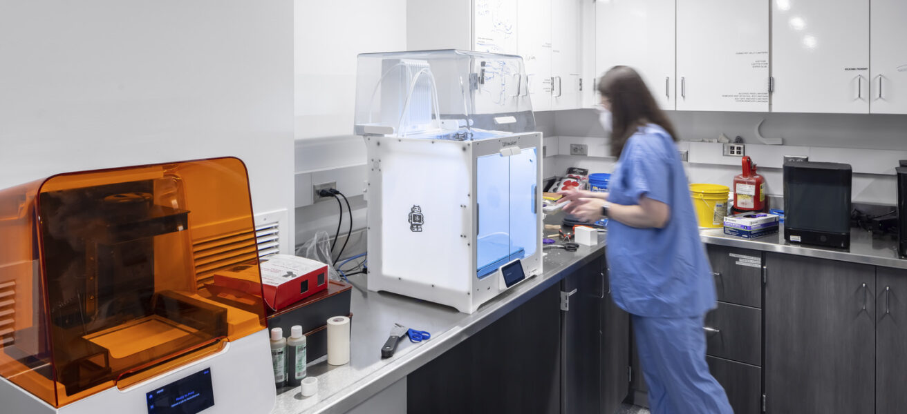 A person uses a 3D printer in the Mayo Clinic simulation space.