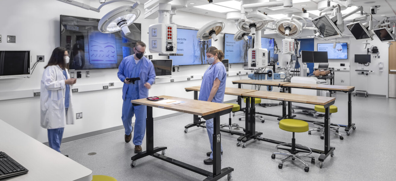 People assemble around an active learning tables in the Mayo Clinic simulation center.