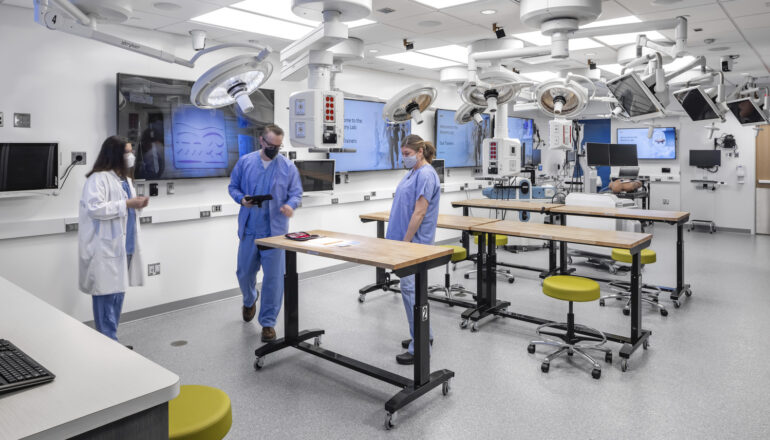 People assemble around an active learning tables in the Mayo Clinic simulation center.