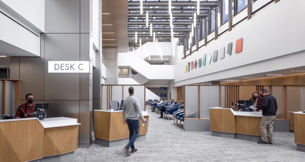 Patients check in for their appointments at the Hilton Atrium Desk C. Several check-in stations ease patient flow and wide open spaces with overhead skylights welcome people into the waiting area