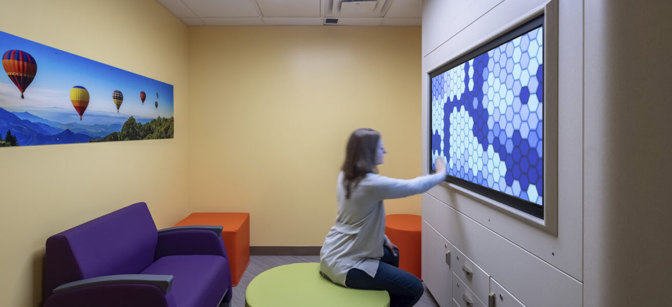 A person does a calming exercise on a touchscreen in a Mayo Clinic psych department sensory room.